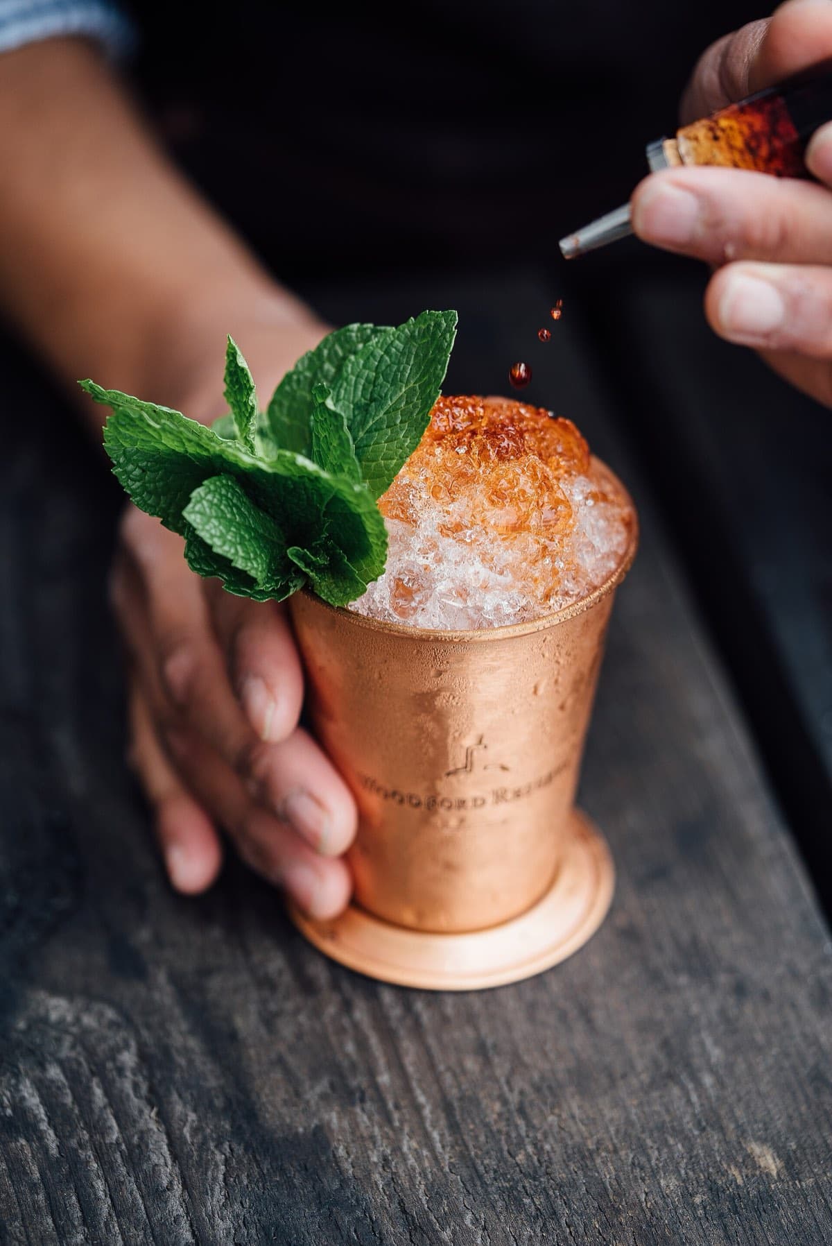 A cocktail in a copper cup garnished with fresh mint