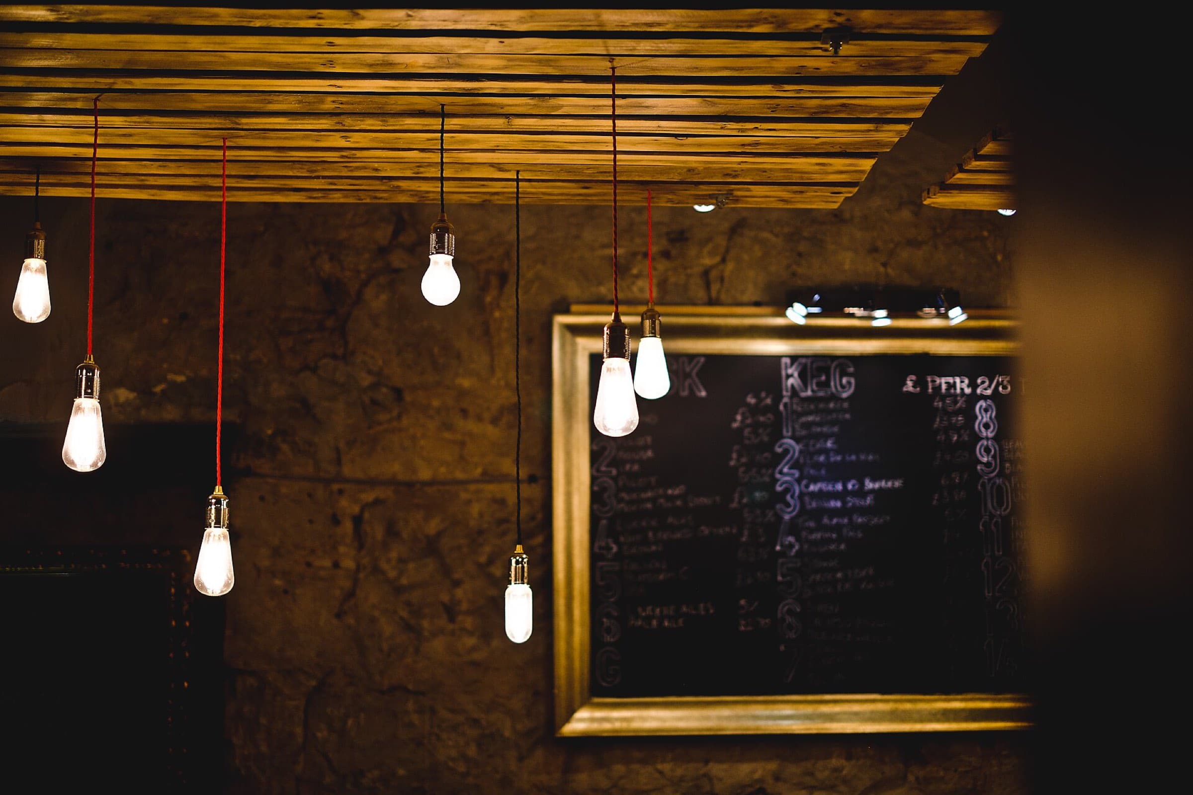 Bare light bulbs glowing above a dark wall with a framed board